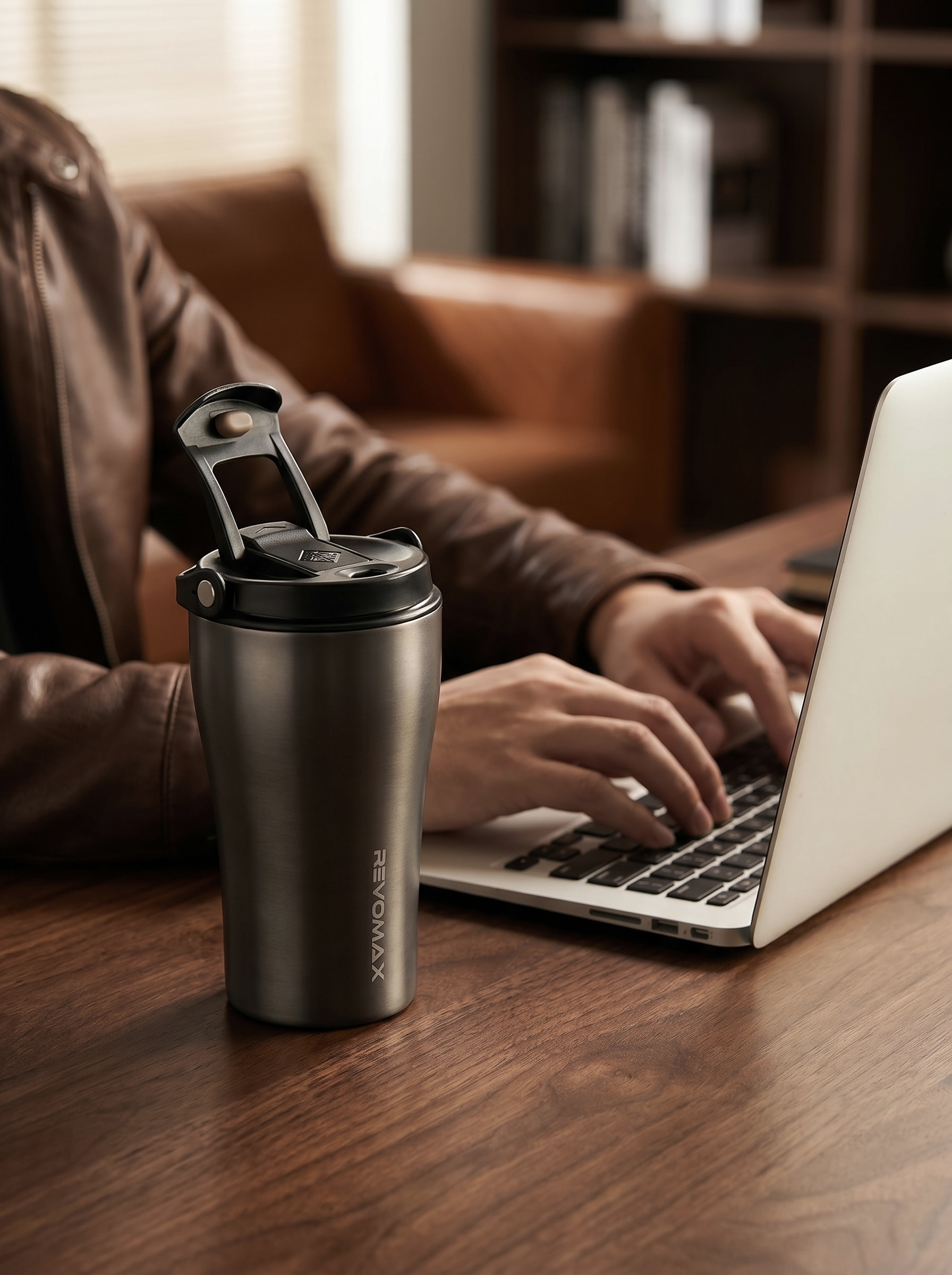 Gunmetal ceramic-coated coffee tumbler on a desk beside a laptop